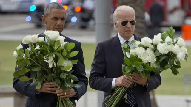 奥巴马和拜登手捧花束悼念遇害者