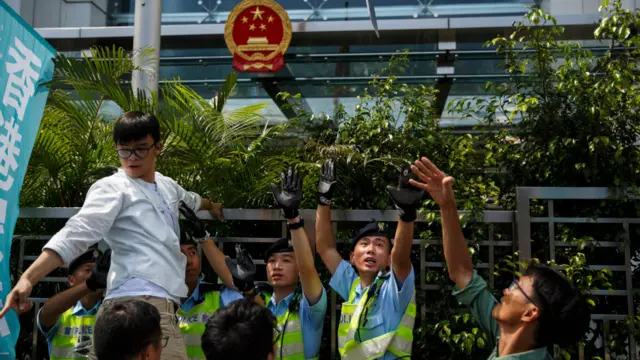 抗议者将纸版投掷进中联办围墙