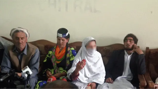 رینا، په سپینو جامو کې، خبریالانو ته وویل هېچا نه ده مجبوره کړې چې مسلمانه شي. نوموړې دلته له دوو کالاش مشرانو او خپل تره سره لیدل کېږي