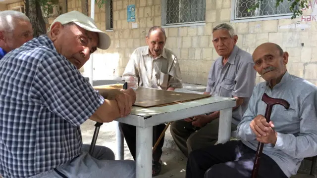 Старики играют в настольные игры у общежития