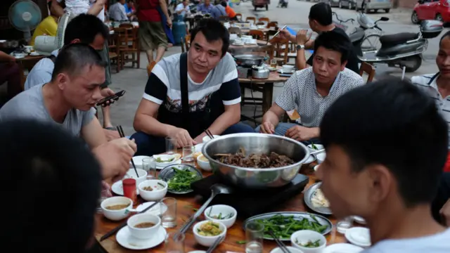 人们在夏天最热的日子里享用狗肉大餐
