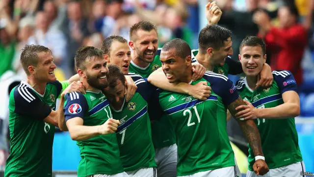 Pemain Irlandia Utara, Josh Magennis dikerubuti rekan-rekannya usai mencetak gol ke gawang Ukraina.