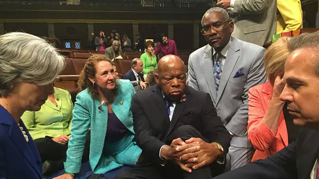 Anggota kongres Amerika dari partai demokrat duduk di lantai sebagai wujud protes.