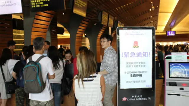 华航在柜台放置大型LED告示牌，提醒游客24日“全面停飞”。