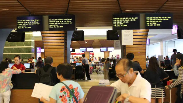 华航柜台的柜台可以看见上方用中英文显示早上六时至晚间十时的班机全面停飞