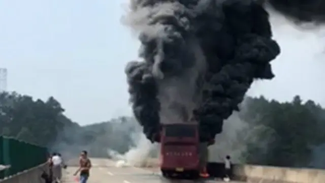 中国湖南省境内高速公路上大巴车撞护栏后起火燃烧。