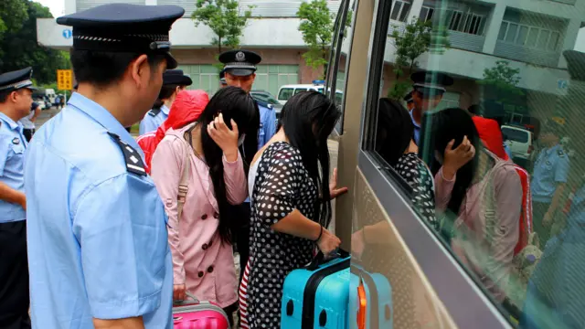 广东珠海警方押解涉嫌跨境卖淫妇女登上小巴送走(中新社资料图片)