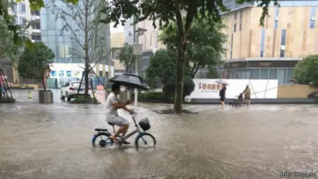 武汉市民在积水和降雨中前行。
