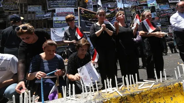 مسيحيون يصلون في موقع تفجير الكرادة على أرواح الضحايا.