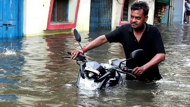 भोपाल में पानी के बीच से होकर जाता एक व्यक्ति.