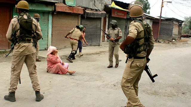 श्रीनगर में प्रदर्शन के दौरान एक व्यक्ति को पीटते पुलिस के जवान.