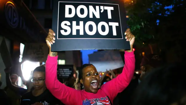 紐約一名黑人女性手舉反對槍殺黑人的紙牌