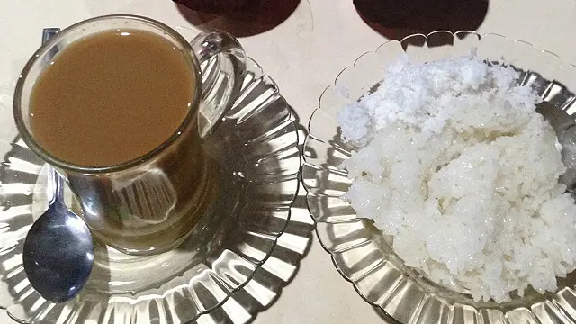 Kawa daun susu disajikan dalam gelas kaca.