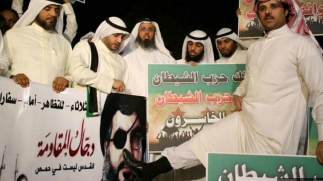 مواطن كويتي يضع قدمه على وجه حسن نصر الله في ملصق احتجاجا على تورط حزب الله في الحرب الدائرة في سوريا 