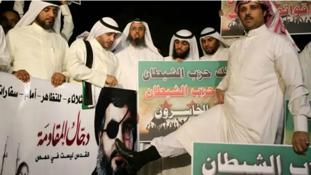 تظاهرات عده ای در کویت در اعتراض به دخالت حزب الله در جنگ داخلی سوریه، یکی از تظاهرکنندگان کفش خود را روی صورت حسن نصرالله گذاشته است.