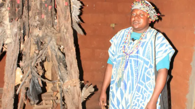 L'un des 9 notables de la cour royale, dans la case sacrée, où il doit se concerter avec ses collègues sur le déroulement des funérailles