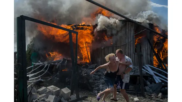 یوکرین کے مشرقی شہر لوہنسکیا میں ڈوبس کے مقام پر شہری ایک فضائی حملے کے بعد ایک مکان سے نکلنے کی کوشش کر رہے ہیں۔ ولیری میلنکوف کی اس تصویر کی فوٹوجرنلزم کیٹیگری میں بہترین تصویر قرار دیا گیا۔ 