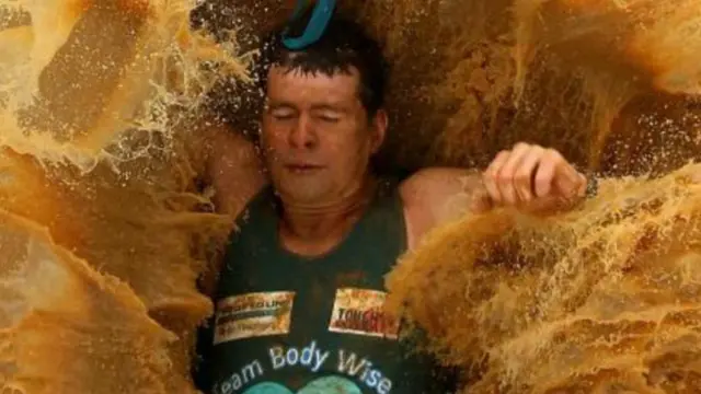 一名参赛者在泥巴硬汉大赛中落水(图片来源:Quinn Rooney/Getty Images)