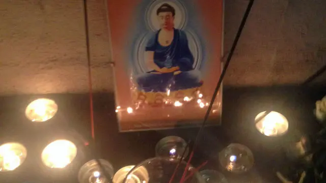 ایک جگہ گوتم بدھ کی تصویر کے ساتھ موم بتیاں روشن تھیں