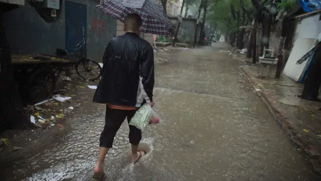 一名男子在北京的雨中走在街上