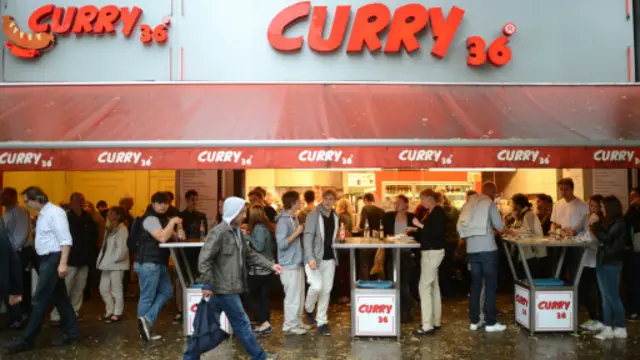 站着和陌生人聊天是吃咖喱肠体验的一部分(图片来源:Getty)