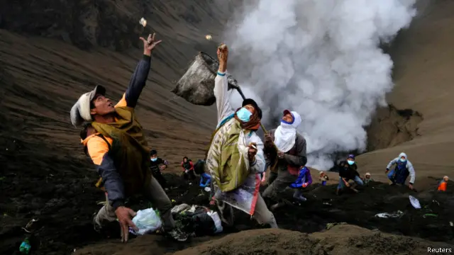 Warga berebut sesaji di kawah Gunung Bromo yang dilemparkan umat yang berdoa dan para wisatawan.
