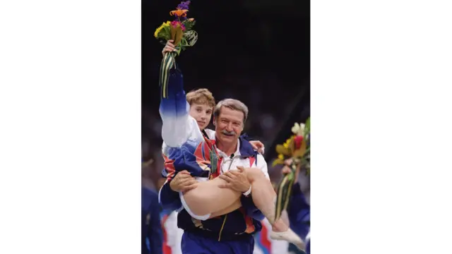 Coach Bela Karolyi carries an injured yet triumphant Kerri Strug of the United States after she received her gold medal in the women's team gymnastics competition at the 1996 Olympic Games in Atlanta, Georgia. Doug Pensinger / Getty Images