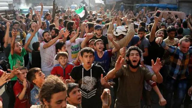 په انځور کې د حلب اوسېدونکي دي چې د کلابندۍ پر ماتېدو خوښي ښيي