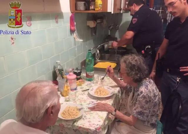 Polis əməkdaşları Jole və Michele-in mətbəxində yemək bişirir.