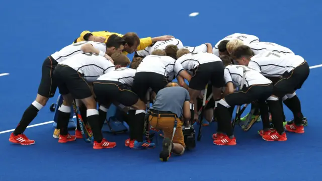 Згори вниз - так німецька чоловіча команда з хокею на траві гуртується перед матчем.