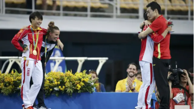 施廷懋非常识趣将一旁的意大利选手拉至一旁，把舞台中心留给秦凯和何姿。