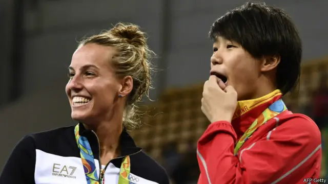 Peraih medali emas dari Cina, Shi Tingmao, dan peraih medali perunggu dari Italia, Tania Cagnotto, menyaksikan prosesi lamaran peraih medali perak, He Zi.