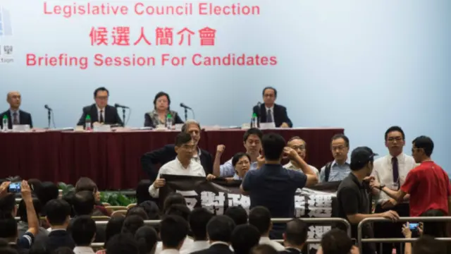 支持民主的人士打著反對「政治篩選的橫幅」