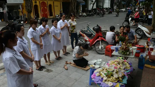 Tại Việt Nam, vào Rằm tháng Bảy, mọi người thường chuẩn bị mâm cúng chúng sinh và quần áo vàng mã. Tại hiệu thuốc tư nhân này, nhân viên đang cầu nguyện trước mâm cúng chúng sinh vào ngày 16 tháng Tám.