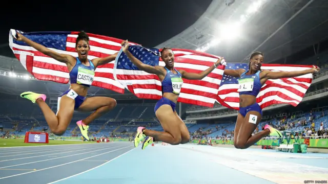 د ښځينه وو د ۱۰۰ متره ځغاستې سياليو کې (له ښې کيڼ اړخ ته) د امریکا د ژېړو مډال ګټوونکې کرېسټي کسټلېن، د سرو زرو مډال ګټونکې بريانا رولېنز او د سپينو زرو مډال ګټونکې نيا علي