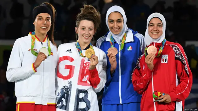 له کيڼ اړخ ښۍ خوا ته، د اسپانيا د سپينو زرو مډال ګټوونکې ايوا کلو ګومز، د بريتانيا د سرو زرو مډال ګټوونکې جېډ جونز او د ايران د ژېړو مډال ګټونکې کيميا علي زاده له خپلو مډالونو سره