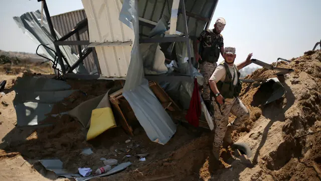 عناصر من حماس تتفقد موقعا تعرض للقصف الاسرائيلي