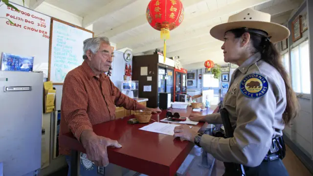 关敏在他的小餐馆内与公园巡警聊天（2011年）