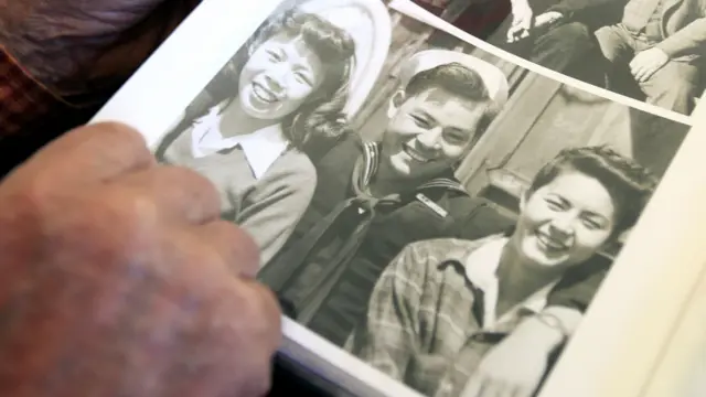 关敏指着他年轻时当兵的照片（2011年）