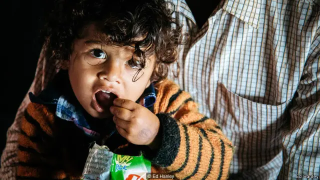 Seorang penumpang menikmati cemilan di atas kereta.