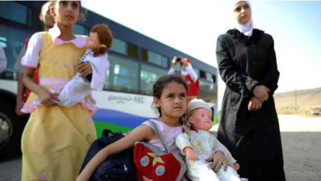 Người Syria sơ tán từ một khu vực bị chiếm đóng đến một thị trấn do quân chính phủ nắm giữ