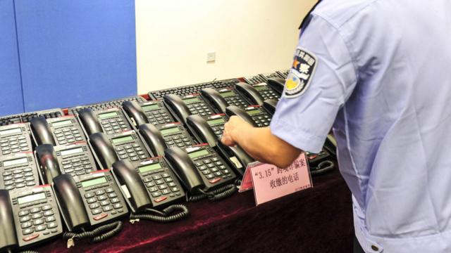 广东警方展示一起跨境电信诈骗案中缴获的电话座机（中新社资料图片）