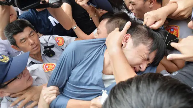 台大澳门学生陈皓扬（前）在台北地方法院外与示威者拉扯（台湾中央社图片16/8/2016）