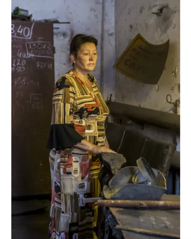 Людмила стоїть біля верстата, за яким працював її чоловік Ігор, що зник безвісти влітку 2015 року. На стіні зварювального цеху написано "Ігор - редиска". Колеги кажуть, що в Ігоря було неймовірне почуття гумору. 