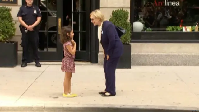 希拉里向支持者招手，並在街頭與一名女童聊天。