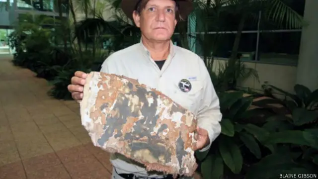  吉布森拿着他在马达加斯加发现的飞机残片