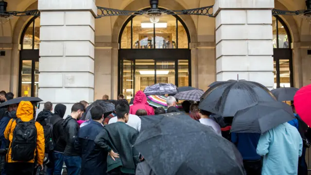 لندن میں بارش بھی خریداروں کو باز رکھنے میں ناکام رہی اور چھاتہ برادر خریدار ایپل سٹورز کے باہر جمع رہے۔