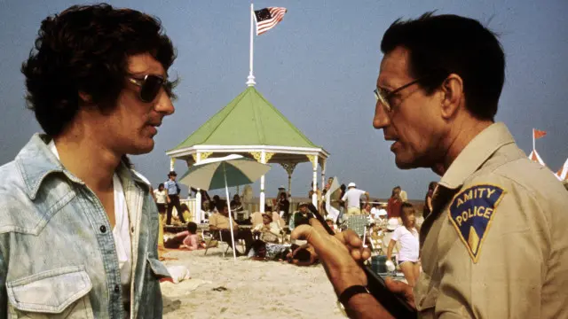 Film Jaws buatan Spielberg (kiri) membuat banyak orang takut berenang di laut.