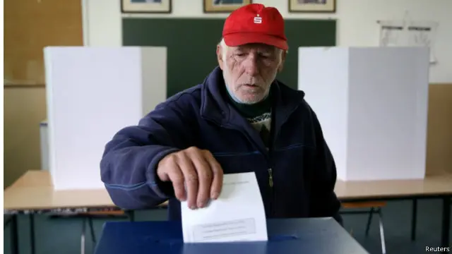 Seorang warga etnik Serbia memasukkan kertas suara dalam referendum di dekat Kota Banja Luka, Minggu (25/9).