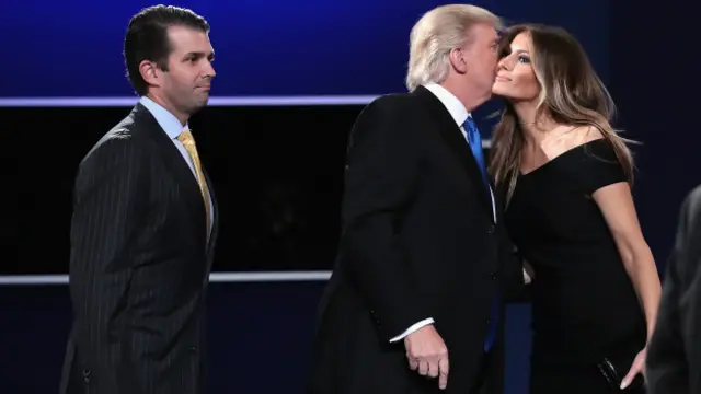 Seusai debat, Trump mencium pipi Melania, istrinya, dan anaknya, Donald Trump, Jr, ikut naik di panggung.